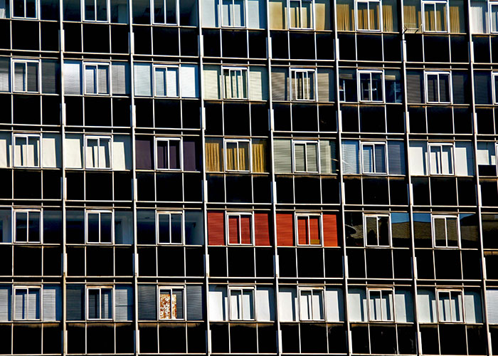 Facade of a modern building with multiple windows reflecting light, illustrating Gen X's balanced experience of old and new worlds.
