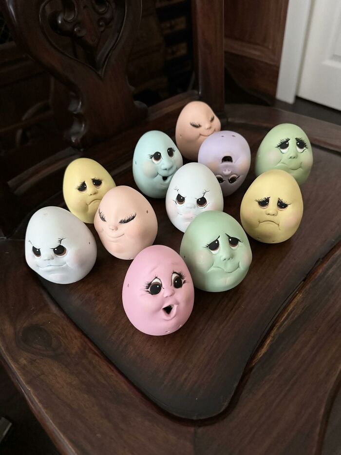 Collection of weird and wonderful thrifted finds featuring vintage pastel-colored eggs with expressive faces on a wooden chair.