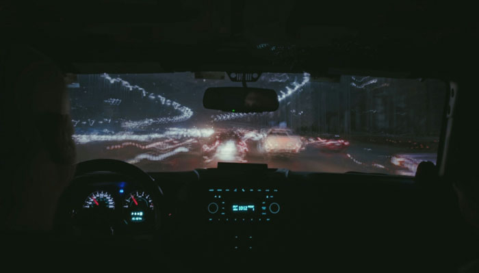 View from inside a car at night with blurred city lights, illustrating one weird rule parents had that seemed normal.