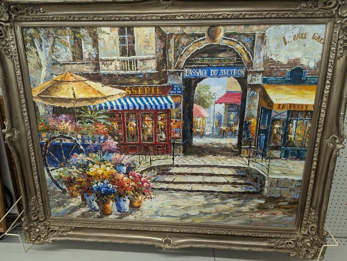 Vintage framed painting of a colorful European street scene, a thrifted find with weird and wonderful charm.