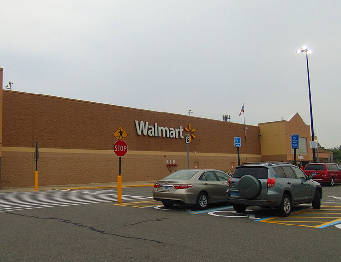 Walmart exterior with parked cars, symbolizing former employees revealing disturbing workplace secrets at retail jobs.