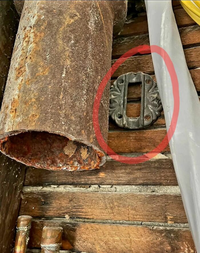 Rusty pipe and a metal plate circled in red found among strange things in homes with hidden forgotten or haunted pasts.