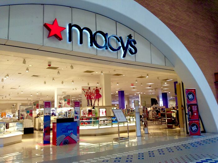 Macy’s store entrance in a mall, showcasing retail displays and promotional signage inside the company location.