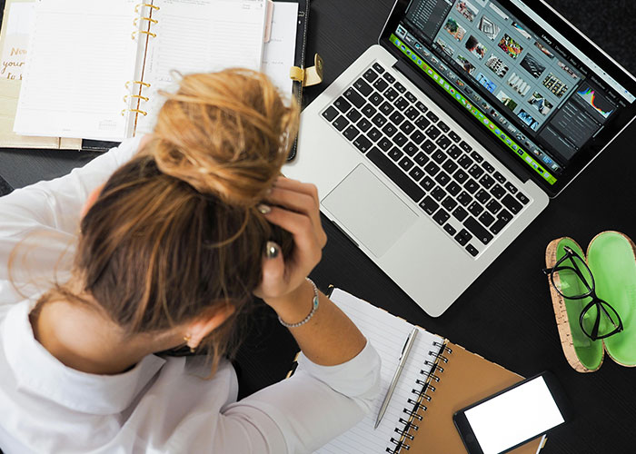 Person working at a laptop surrounded by notebooks, sharing entertaining facts in a popular online thread on X.