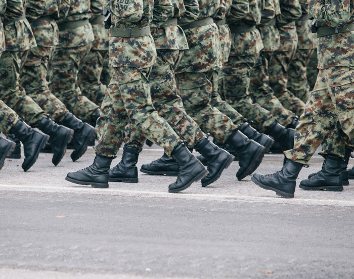 Soldiers in camouflage uniforms marching in formation, symbolizing discipline and unity in long-term friendship.