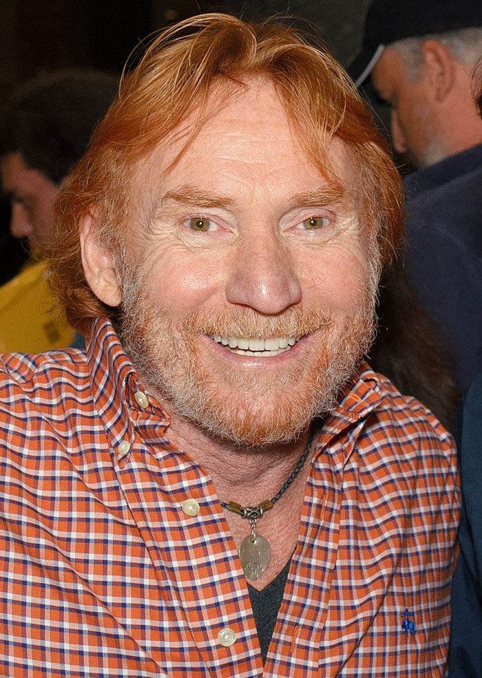 Close-up of a smiling man with red hair and beard wearing a checkered shirt showcasing a memorable celebrity encounter moment.