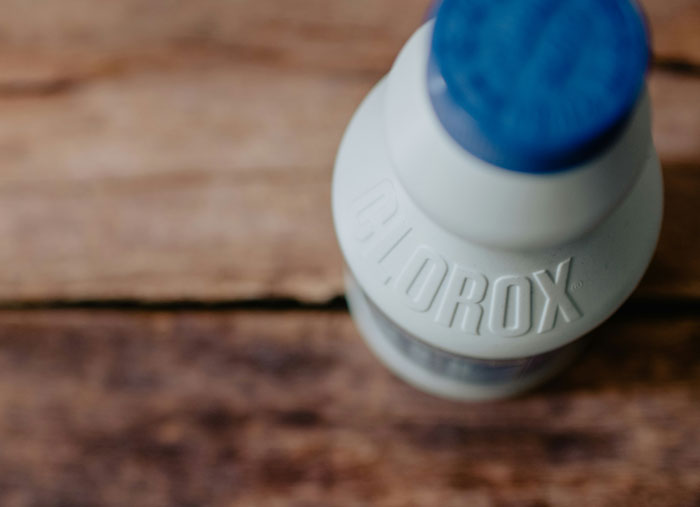 Top view of a Clorox bottle on a wooden surface, illustrating a weird habit linked to being raised poor.