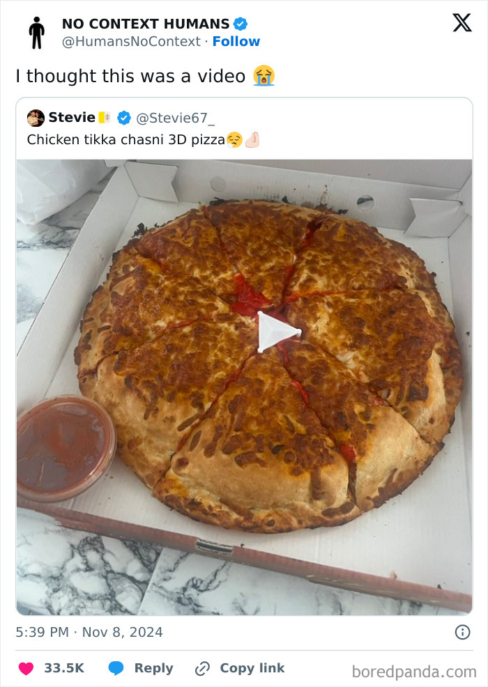 Pizza with melted cheese and tomato sauce in a box, resembling a video play button in the center, requiring a double take.