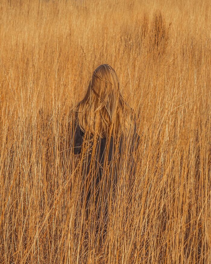 Person blending into tall grass in a creative photo edit showcasing good visual lies and surreal effects.