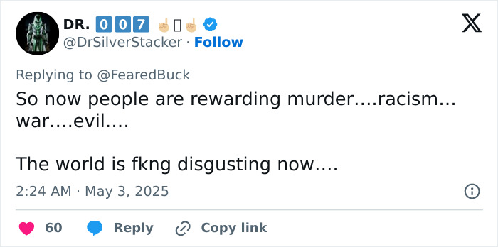 Tweet by Dr. 007 commenting on society rewarding racism and expressing disgust with the current state of the world.