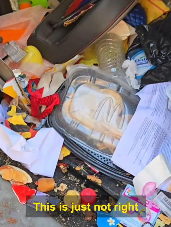 Filthy car interior cluttered with trash, food containers, and papers showcasing extreme mess before cleaning effort.