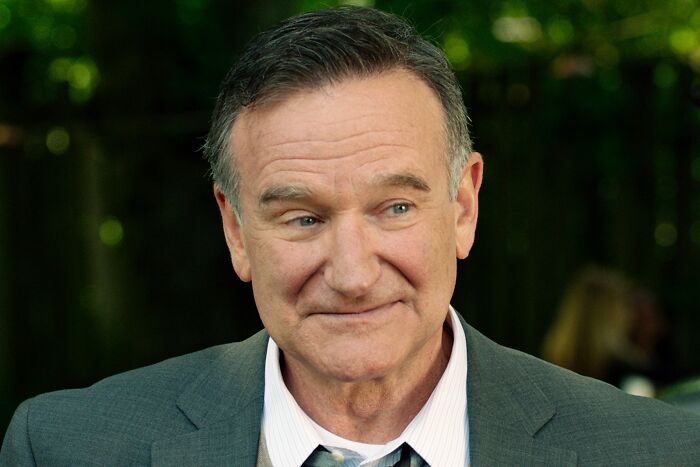 Middle-aged man in a gray suit smiling thoughtfully outdoors, illustrating fascinating today I learned facts and new insights.