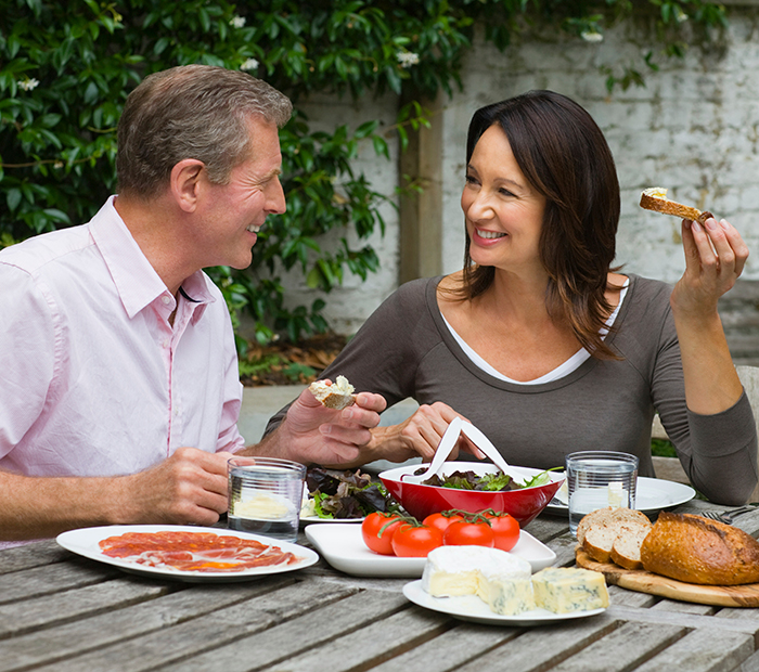 Man and woman enjoying an outdoor meal together, representing stepmother and family dynamics with teen refusal theme.