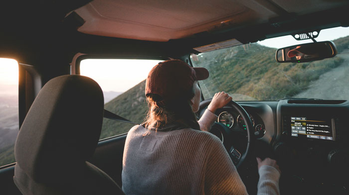 Graduate driving a car on a mountain road, illustrating a trip refusal amid family babysitting emergency drama. Graduate driving a car on a mountain road, illustrating a trip refusal amid family babysitting emergency drama.