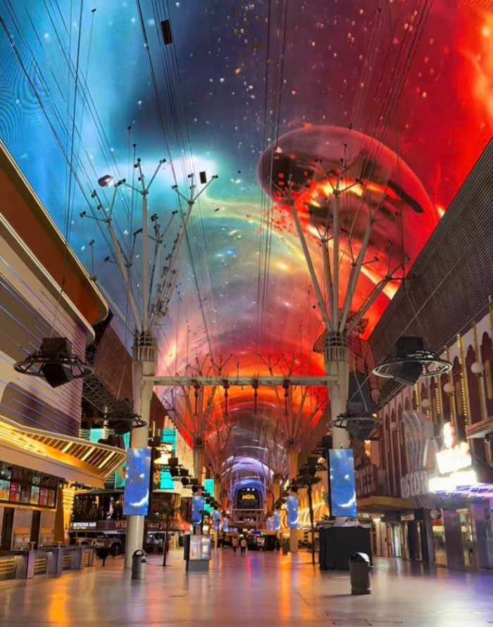 Vibrant indoor street scene with colorful ceiling lights and empty walkways reflecting US tourism sector decline.