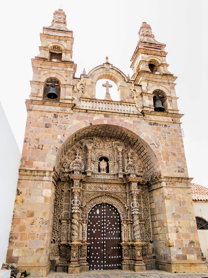 Ornate historic church entrance with intricate stone carvings and twin bell towers, a stunning UNESCO treasure site.