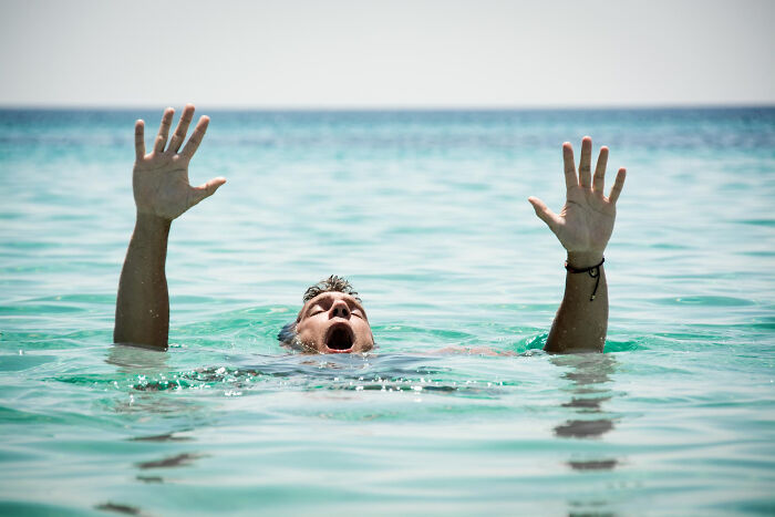 Man struggling to stay afloat in water, illustrating casual things that can actually be deadly, like drowning risks.