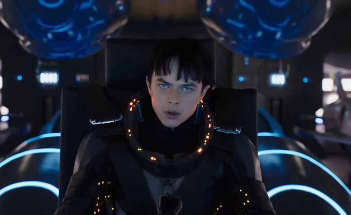 Young male actor in futuristic suit seated in a high-tech vehicle, representing miscast actors in popular movies.
