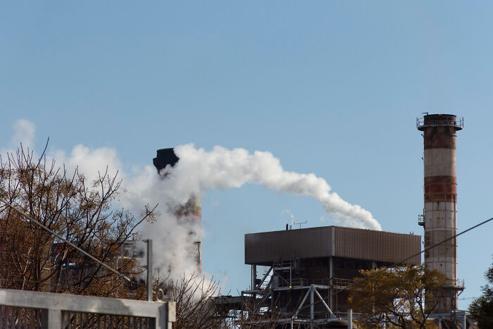 Industrial factory emitting smoke through chimneys, illustrating casual things that can actually be deadly risks.