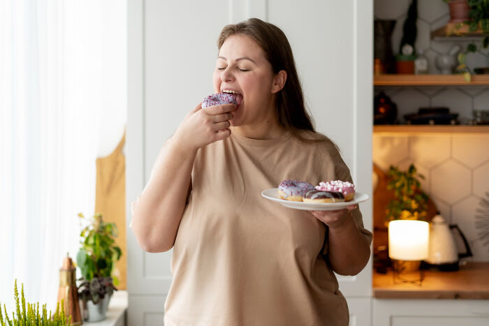 Woman enjoying sweet donuts at home, illustrating casual things that most people don't realize can be deadly.