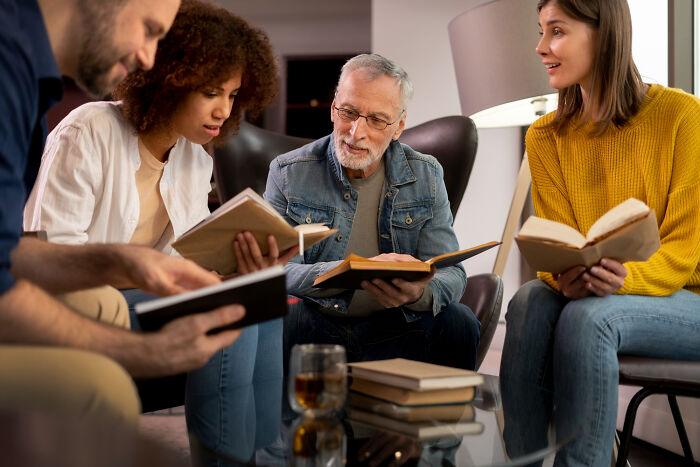Group of adults reading books together, capturing moments from an adult life that feel like being picked last in gym class.
