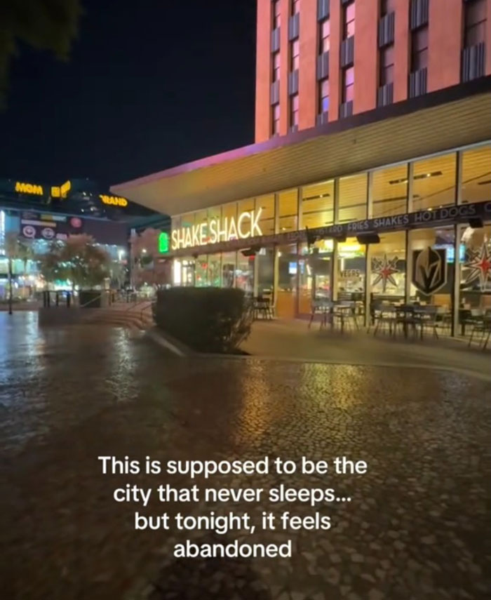 Empty outdoor seating area of a Shake Shack at night, highlighting the US tourism decline and lack of visitors.