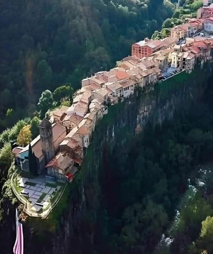 Aerial view of an unusual cliffside village with buildings perched on the edge, highlighting odd things found on Google Earth.