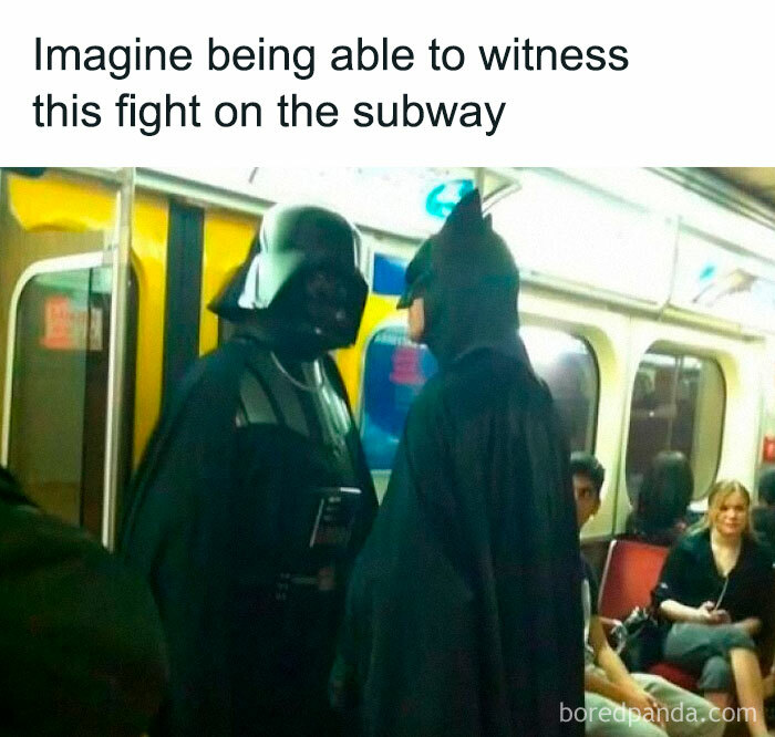 Two people dressed as Darth Vader and Batman face each other humorously on a subway, a funny meme moment.