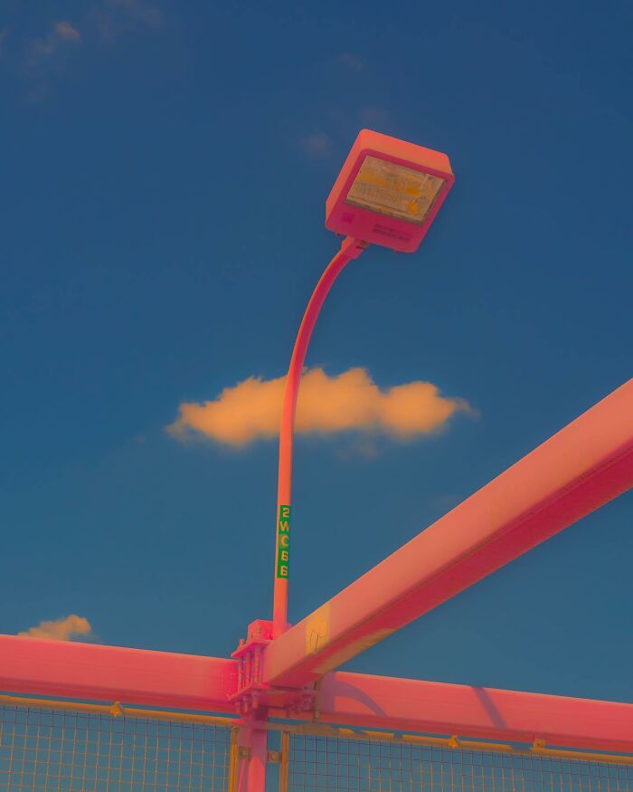 Street lamp with vibrant pink photo edits under a deep blue sky, showcasing creative visual lies that question reality.