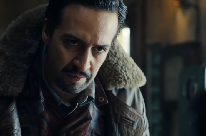 Actor wearing a fur-lined jacket with a serious expression, representing miscast actors in movies.