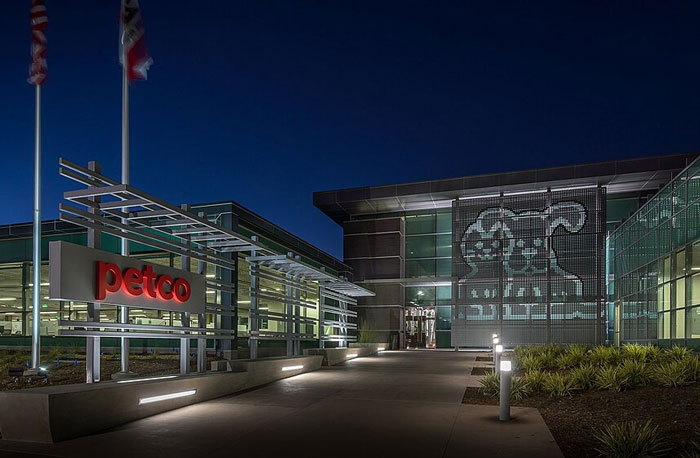 Petco corporate building at night with illuminated logo, relating to former employees revealing disturbing workplace secrets.