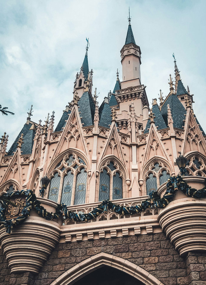 Gothic castle towers with intricate details under a cloudy sky, illustrating dark family secrets and hidden stories.