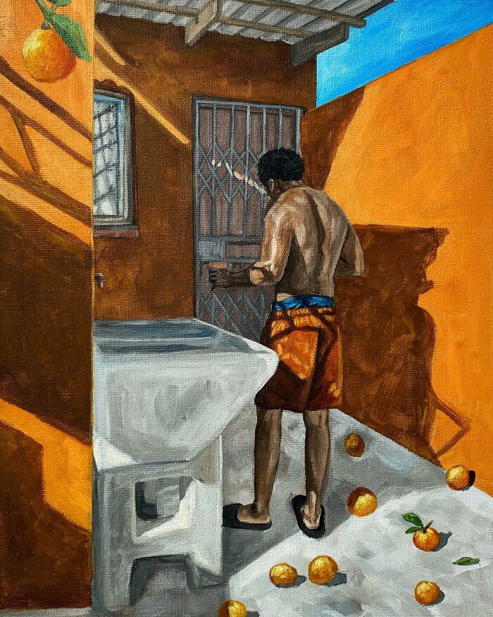 Man in orange shorts standing by a gate in a vibrant orange-walled space with scattered oranges, showcasing color and space.