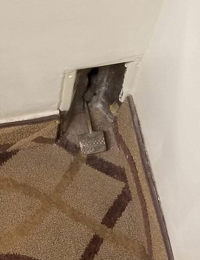 Small hidden wall opening under carpet with a strange metal hammer inside found in a home with a hidden past