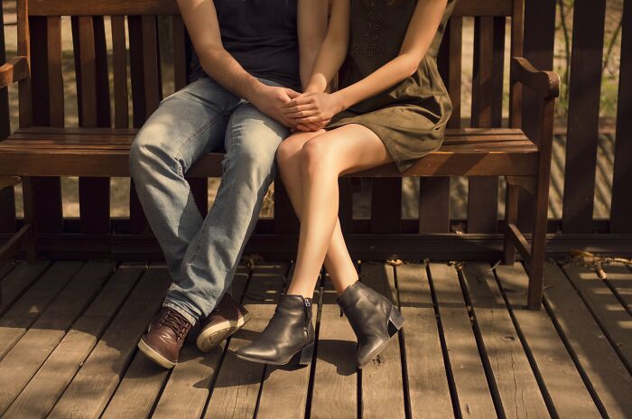 Couple sitting closely on a wooden bench holding hands, illustrating harshest pieces of when life gives you lemons advice.