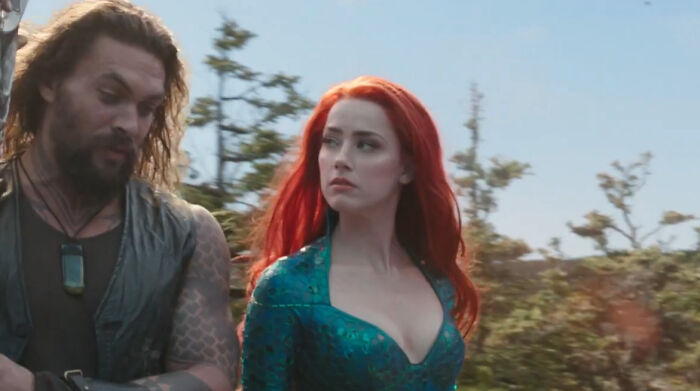 Jason Momoa and Amber Heard in a fantasy movie scene, two miscast actors in a controversial film role outdoors.