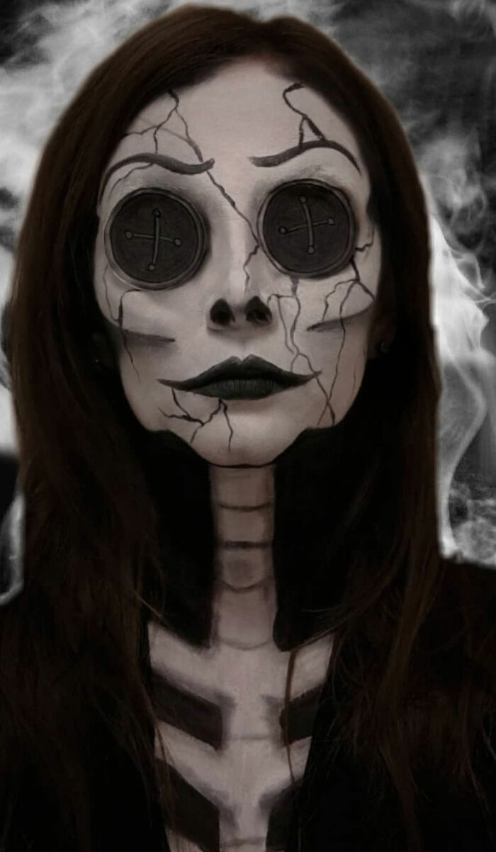 Woman with c*****d doll makeup and button eyes, showcasing a creative and eerie makeup look by talented artists.