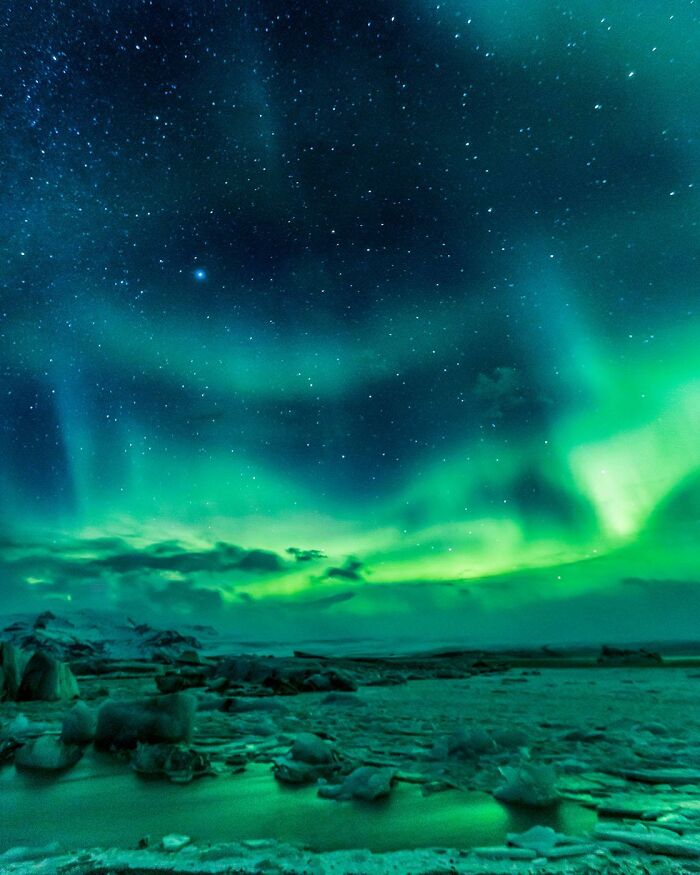 Green and blue aurora borealis lighting up the night sky over a snowy landscape capturing rare natural phenomena.
