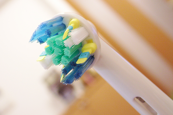 Close-up of an electric toothbrush head highlighting a woman suspecting her boyfriend is messing with her toothbrush.