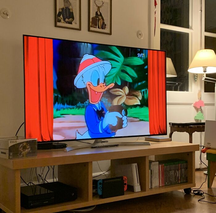 Donald Duck cartoon playing on TV in a cozy living room illustrating cultural differences in media perception.