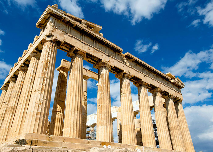 Parthenon temple columns under a blue sky representing the best and worst things about living in home countries.