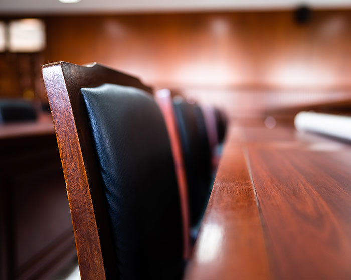 Empty courtroom chairs lined up along a wooden bench, symbolizing the major twist in Diddy case testimony disappearance.