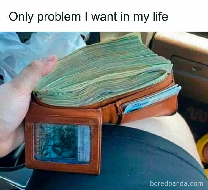 Hand holding a wallet stuffed with cash, representing a hilarious meme about an ideal problem in life.