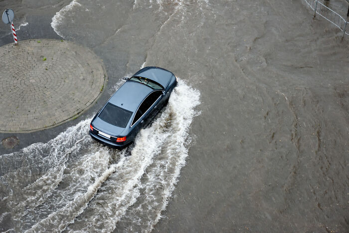 Car driving through deep flood water, illustrating casual things that can actually be deadly in everyday life.