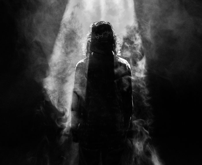 Silhouetted person surrounded by smoke, symbolizing escape and mystery related to cults and personal stories.
