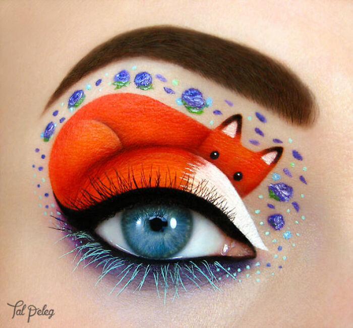 Eye makeup featuring a vibrant fox design with detailed brush strokes and blue floral accents in an incredible makeup look.