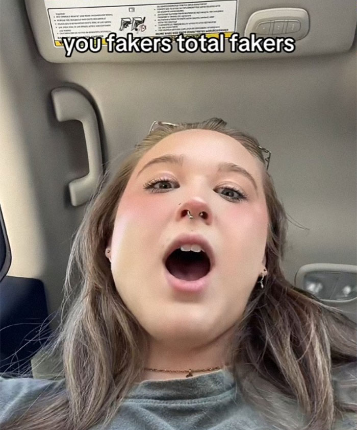 Woman with POTS in a car reacting to harassment for not looking disabled enough while using a parking permit.