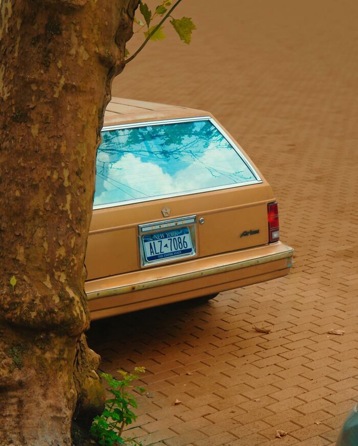 Vintage car with a rear window showing a sky reflection, showcasing creative photo edits that make you question reality.