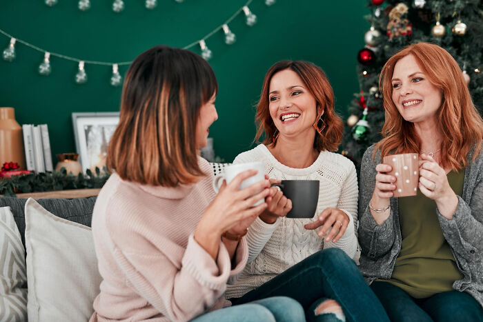 Three women enjoying coffee and conversation, capturing moments from adult life that feel like being picked last in gym class.