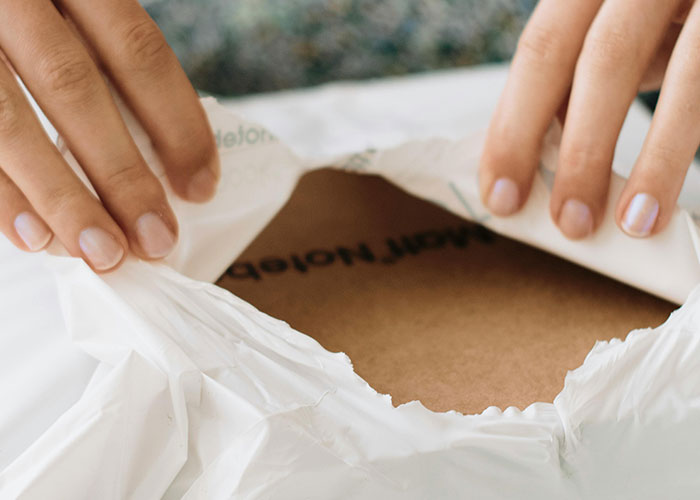 Hands opening a package, illustrating a woman dealing with a neighbor stealing packages in a petty response.